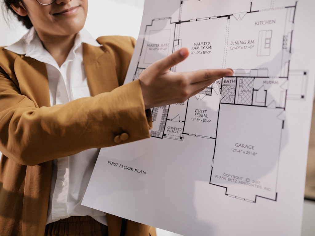 agente mostrando los planos de una casa a un comprador que agendo usando su software de citas para agentes inmobiliarios