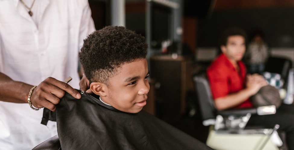 niño en una barberia esperando su corte de pelo